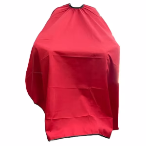 Capa de peluquería de color rojo vibrante extendida, mostrando su acabado satinado y gran tamaño.