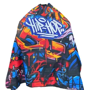 Capa de barbería profesional XL modelo PB-044 con diseño de graffiti multicolor y la palabra "Hip-Hop" en letras azules y blancas sobre fondo negro.